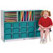 A girl sitting on a stool in front of a Rainbow Accents teal storage cabinet with trays.