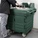 A man using a Cambro green portable hand sink on a counter.