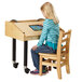 A girl sitting at a wooden table using a Jonti-Craft wood tablet table.