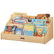 A Jonti-Craft wooden pick-a-book stand filled with children's books and a stuffed animal.