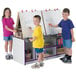 Three children using a purple and white Rainbow Accents art center to write on a white board.