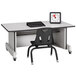 A Rainbow Accents black laminate computer desk with a computer and chair on wheels.
