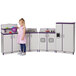 A little girl playing with a purple and white Rainbow Accents kitchen set.