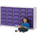 A young girl sitting on the floor reading a book in front of a Rainbow Accents purple storage unit.