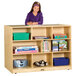 A girl standing behind a double-sided wood storage island with books on it.