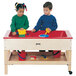 A boy and girl playing with a Jonti-Craft mobile wood sensory table filled with red and blue sand.