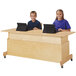 A boy and girl sitting at a Jonti-Craft double computer desk with laptops.