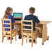 A boy and girl sitting at a Jonti-Craft double computer desk with laptops.