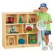 A child standing next to a Jonti-Craft mobile wood storage cabinet filled with insects.
