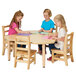 Three children sitting at a Jonti-Craft adjustable height table drawing.