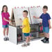 Three children using a Rainbow Accents 4-station art center to write on a white board.