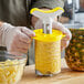 A person using a Vacu Vin pineapple corer to slice a pineapple.