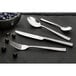 An Amefa stainless steel butter knife on a black surface.