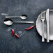 An Amefa stainless steel European table fork on a white plate with a spoon and knife.