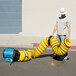 A man holding a large yellow XPOWER ventilation duct hose.