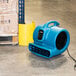 A blue XPOWER air blower on a cart.