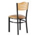 A Lancaster Table & Seating dining chair with a natural wood back, black frame, and tan cushioned seat.