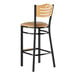 A Lancaster Table & Seating black bar stool with a light brown cushioned seat and natural wood back.