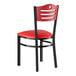 A black metal Lancaster Table & Seating chair with red vinyl seat and mahogany wood back.