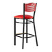 A Lancaster Table & Seating red vinyl bar stool seat with black legs and mahogany wood back.