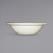 A close up of an International Tableware Victoria ivory stoneware bowl with a scalloped rim.