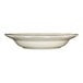 A scalloped edge ivory stoneware pasta bowl with a black rim.
