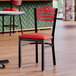 A Lancaster Table & Seating black chair with a red vinyl seat.