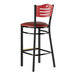 A black Lancaster Table & Seating restaurant bar stool with mahogany accents and a red vinyl seat.