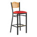 A Lancaster Table & Seating black side bar stool with a red vinyl seat and natural wood back.