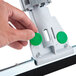 A hand holding a Unger SmartFit Sanitary Scrubbing Brush/Squeegee with a green button.