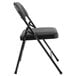 A National Public Seating black metal folding chair with black fabric seat.