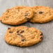 Preformed Rich's Jacqueline vegan oatmeal raisin cookies on a wooden surface.