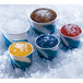 A white bucket of ice with a cup of ice in it.