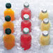 A Manitowoc remote condenser ice machine with bottles of yellow, orange, and red drinks on ice.