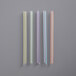 A group of colorful plastic straws with multicolored stripes.