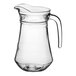 A clear glass Acopa pitcher with a handle.