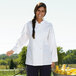 A woman wearing a Uncommon Chef white long sleeve chef coat.