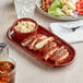 An Acopa Sedona Orange stoneware platter with chicken and coleslaw on a table.