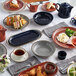 An Acopa Azora Blue stoneware saucer on a table with food and a cup of coffee.