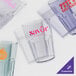 A close-up of a clear blue plastic tumbler with pink text.