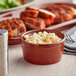 A bowl of macaroni and cheese in an Acopa Sedona Orange stoneware ramekin on a table.