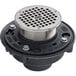 A black Zurn floor and shower drain with a silver metal round cover.