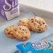 A tray of Nabisco Chips Ahoy! chocolate chip cookies next to a purple and white carton of milk.