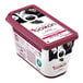 A container of black currant yogurt with berries.