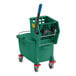 A green Lavex mop bucket with a handle and red wheels.