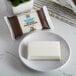 A white rectangular Soapbox Sea Minerals and Blue Iris soap bar on a white plate.