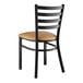 A Lancaster Table & Seating black metal chair with light brown vinyl padded seat.