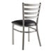 A Lancaster Table & Seating metal ladder back chair with a black vinyl seat.