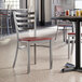 A Lancaster Table & Seating ladder back chair with a mahogany seat on a table in a restaurant.