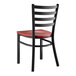 A black metal Lancaster Table & Seating ladder back chair with mahogany wood seat.
